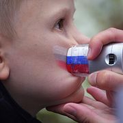 Ryska flaggan ansiktsmålas på en pojke inför ett firande i St Petersburg, 2025.