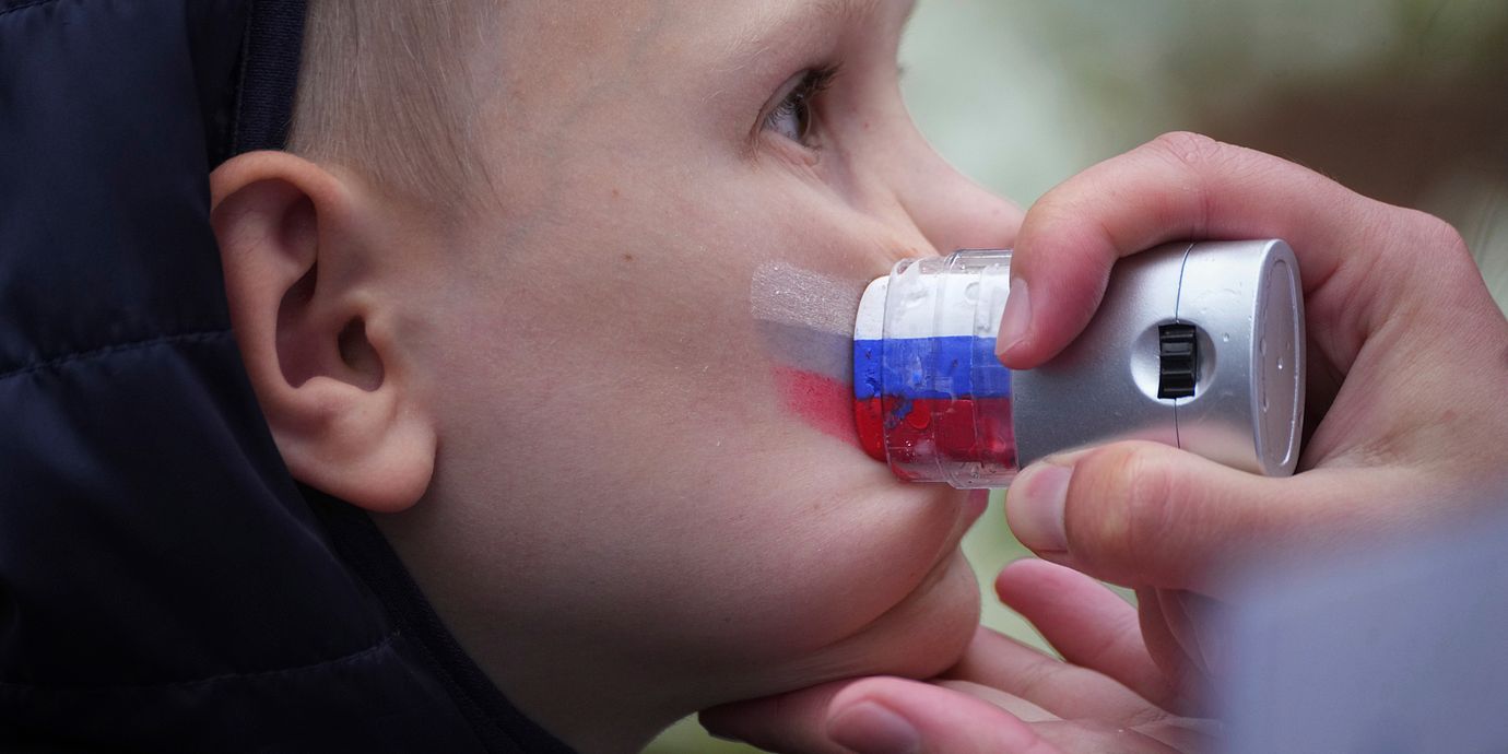 Ryska flaggan ansiktsmålas på en pojke inför ett firande i St Petersburg, 2025.