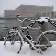 Vinter i Stockholm. Parkerad cykel och slottet i bakgrunden.