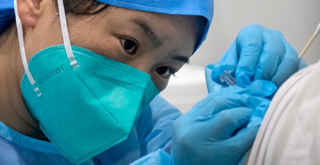 Sjuksköterska i Peking ger patient vaccin. Mark Schiefelbein / TT NYHETSBYRÅN