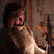 Tetjana Tatarenkova har tänt levande ljus bredvid sin fågelbur under ett strömavbrott, 13 januari.