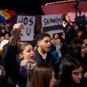 Demonstranter håller upp skyltar med texten ”UT C.U” och ”Satanist” under en protest mot Calin Georgescu i Bukarest på tisdagskvällen. 