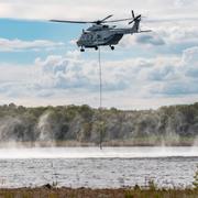 Försvarsmaktens helikopter fyller på sin brandtunna. 