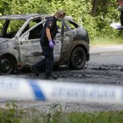 Polisen undersöker den utbrända bilen