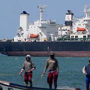 Fiskare framför en oljetanker i Punta Cardon, Venezuela.