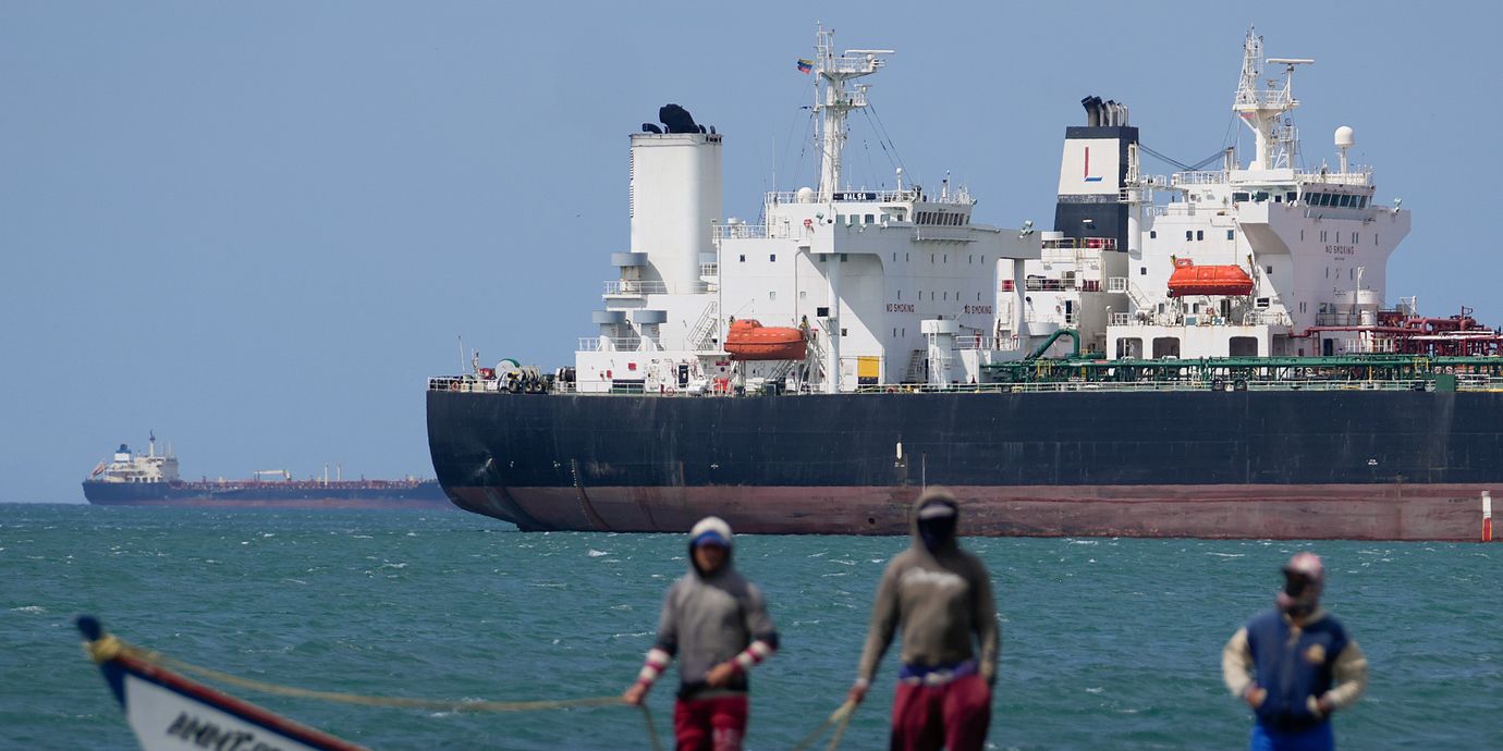 Fiskare framför en oljetanker i Punta Cardon, Venezuela.