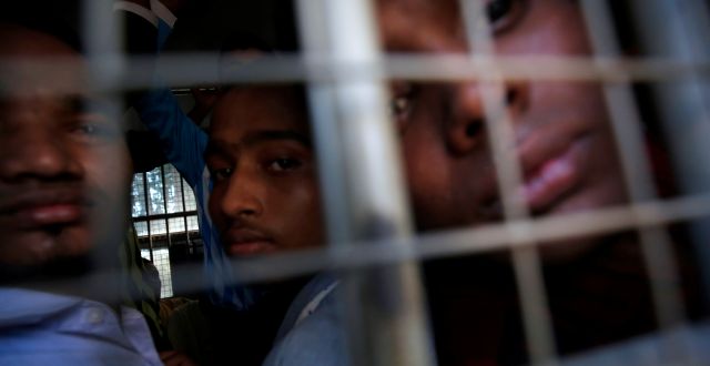 Män tillhörande folkgruppen rohingyer blickar ut från en polisbil efter att ha blivit anklagade för att resa utan rätt dokument.  ANN WANG / TT NYHETSBYRÅN