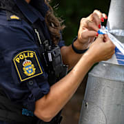 En polis på plats och spärrar av en misstänkt brottsplats. Arkivbild. 