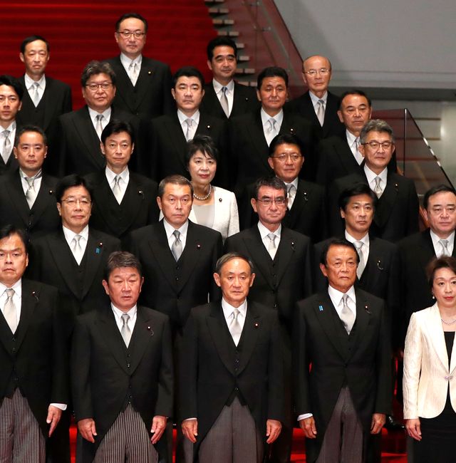 In this Sept. 16, 2020, file photo, Japan's Prime Minister Yoshihide Suga, front center, and his cabinet ministers pose for a photo session at Suga's official residence in Tokyo. Issei Kato / AP