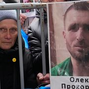 Människor i Ukraina håller upp bilder på saknade soldater. Bilden är från den 11 april i år.