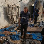 Palestinier vid platsen där flera journalister dödades i ett israeliskt anfall. 