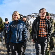 Per-Albin Hansson, svensk statsminister innan och under andra världskriget (t v), Magdalena Andersson och Ulf Kristersson under en militärövning 2022 (t h)