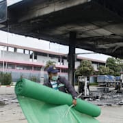 En arbetare utanför en nedbränd bensinmack 2022. Även då drabbades regionen av en våg av attacker.