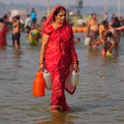 En kvinna hämtar vatten i floden Ganges i Indien.