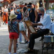 En flicka får sitt porträtt målat i Montmartre i Paris tidigare i veckan. 