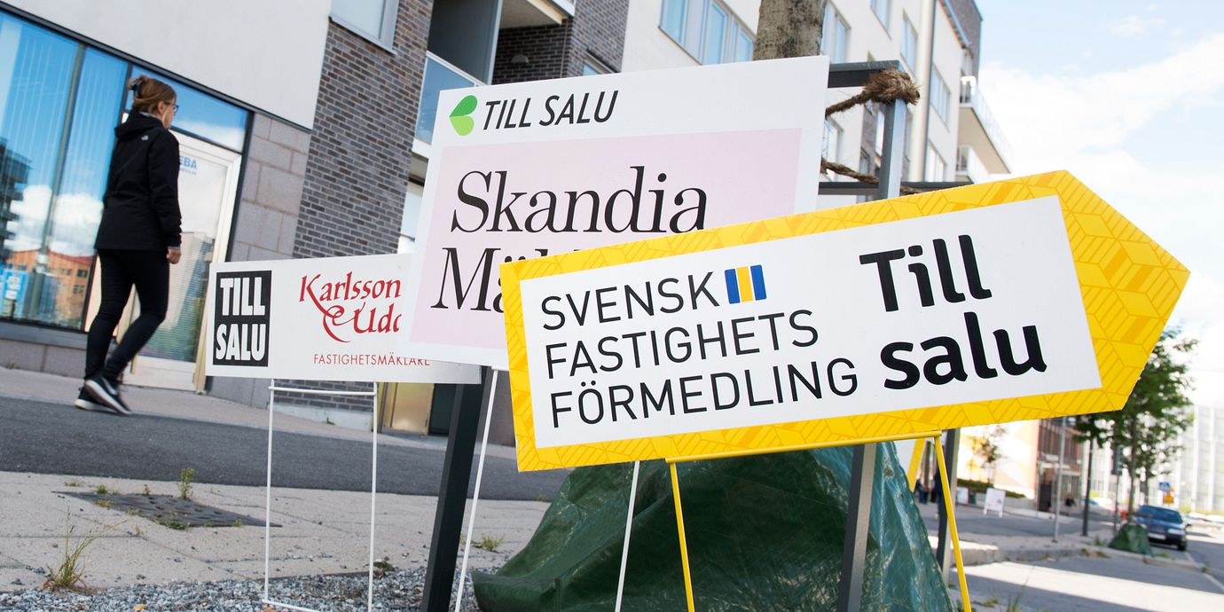 Skyltar från olika mäklarfirmor gör reklam för lediga lägenheter. Illustrationsbild.