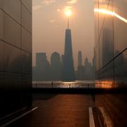 The One World Trade Center tower in lower Manhattan in New York City is pictured from the Empty Sky 911 Memorial in Jersey City, New Jersey, shortly after sunrise as haze and smoke caused by wildfires in Canada hangs over the Manhattan skyline in New York, U.S., June 8, 2023.