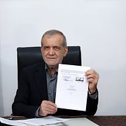 Irans president Masoud Pezeshkian håller upp det underskrivna avtalet med USA.