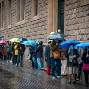 Människor går till valurnorna i regnigt Barcelona