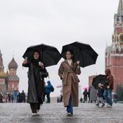 Två kvinnor i regnet i Moskva. 