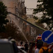 Räddningstjänsten släcker bränder i Kyiv efter fredagens attacker.