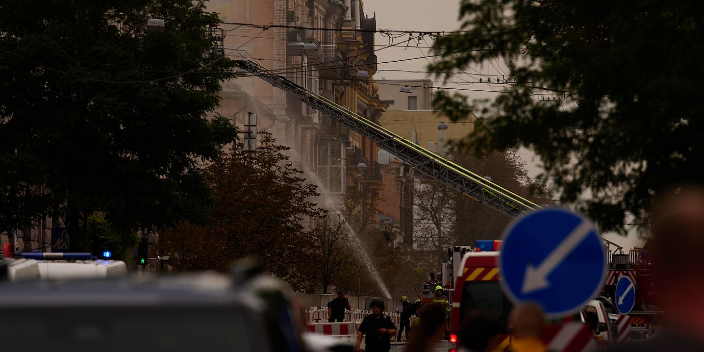 Räddningstjänsten släcker bränder i Kyiv efter fredagens attacker.