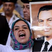Anhängare till Mubarak protesterar utanför domstolen.