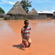 En pojke står utanför sitt hem i Tana Delta i Kenya. 