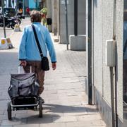 Kvinna drar en shoppingvagn, Stockholm.

