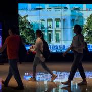 Shoppingcenter i Peking, Kina. På skärmen visas nyheten att Joe Biden hoppar av presidentvalskampanjen. 