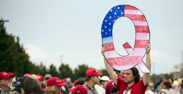 En man håller upp ett skylt med ett Q för Qanon under ett Trump-rally 2018.  Matt Rourke / TT NYHETSBYRÅN