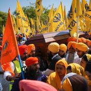 Sikhledaren Hardeep Sing Nijjar sökts till döds av maskerade män på parkeringsplatsen utanför sitt tempel. Hans begravdes omgärdad av Khalistan-flaggor.  Darryl Dyck / AP