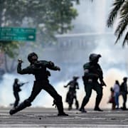 Polis kastar tårgas i samband med massdemonstrationerna efter valet 2024. 