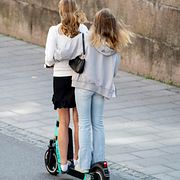 Två personer åker på en elsparkcykel