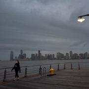 Kvinna promenerar vid Hudsonfloden i New York.