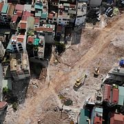 En väg anläggs rakt igenom ett bostadskvarter i Hanoi.