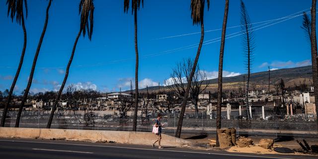 Fotgängare passerar branddrabbat område på Maui. Stephen Lam / AP