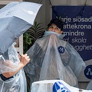 Moderater i moderata regnponchos på Sergels torg i Stockholm.