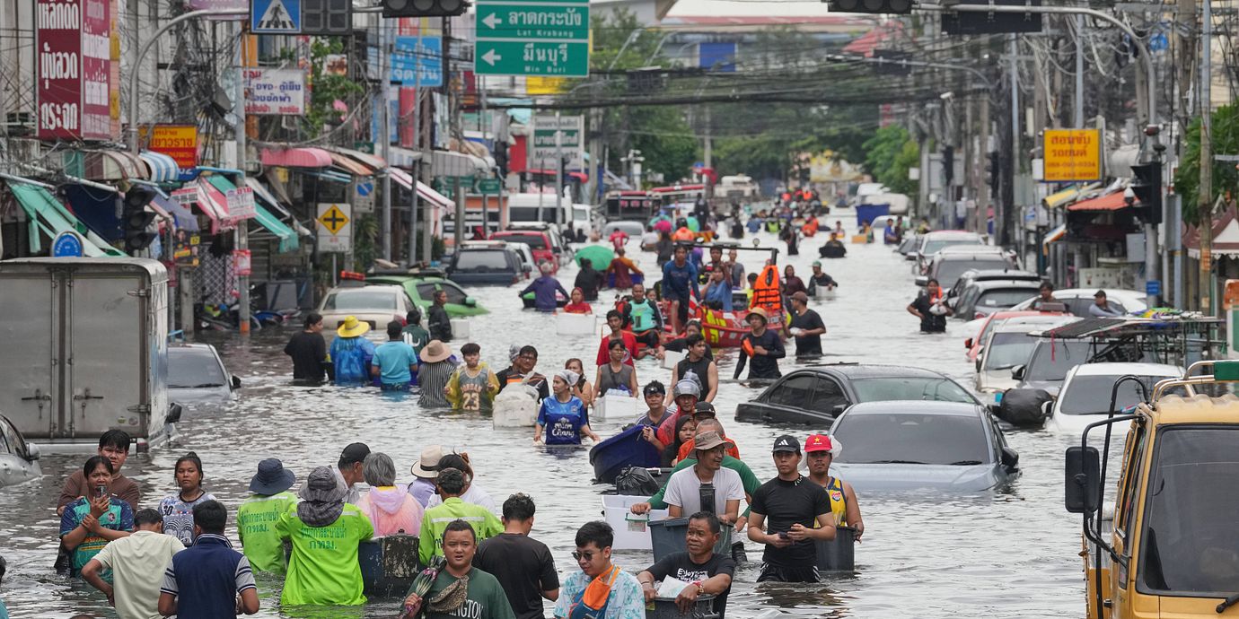 Folk vadar genom vattnet på en gata i Bangkok.