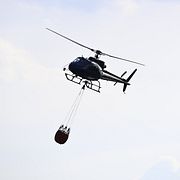 Arkivbild av en helikopter med en vattenbomb.