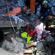 Familj räddas ur rasmassorna i Zaporizjzja på lördagen.