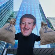 Demonstrant i Zuckerberg-mask protesterar mot låg techskatt utanför Metas Londonkontor, 13 maj 2025.