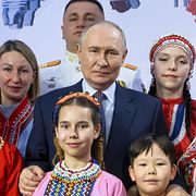 Vladimir Putin poserar tillsammans med medlemmar ur etniska minoritetsgrupper i Ryssland vid en tillställning i slutet av april.
