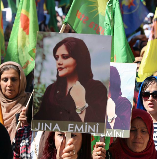 In this photo provided by Kurdish-run Hawar News Agency, Kurdish women hold portraits of Iranian Mahsa Amini, during a protest condemning her death in Iran, in the city of Qamishli, northern Syria, Monday, Sept. 26, 2022.  AP