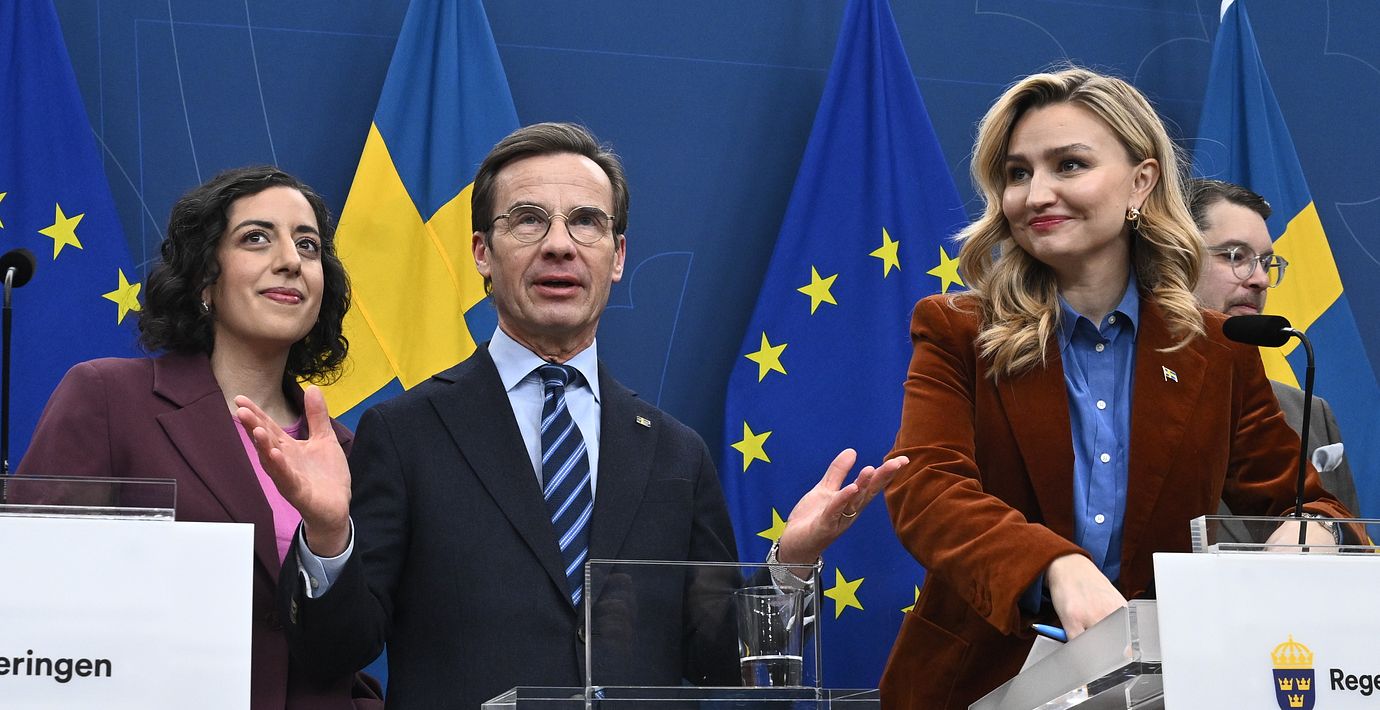Statsminister Ulf Kristersson (M), flankerad av energi- och näringsminister Ebba Busch (KD) och utbildnings- och integrationsminister Simona Mohamsson (L). I bakgrunden skymtar SD:s Jimmie Åkesson.