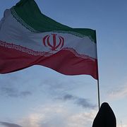 En kvinna håller den iranska flaggan.