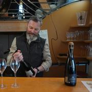 Vinbonden David Levasseur öppnar en flaska champagne.