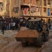 Invånare på Gazaremsan ser på när Hamas-medlemmar söker efter kroppar tillhörande gisslantagna israeler, 17 oktober. 
