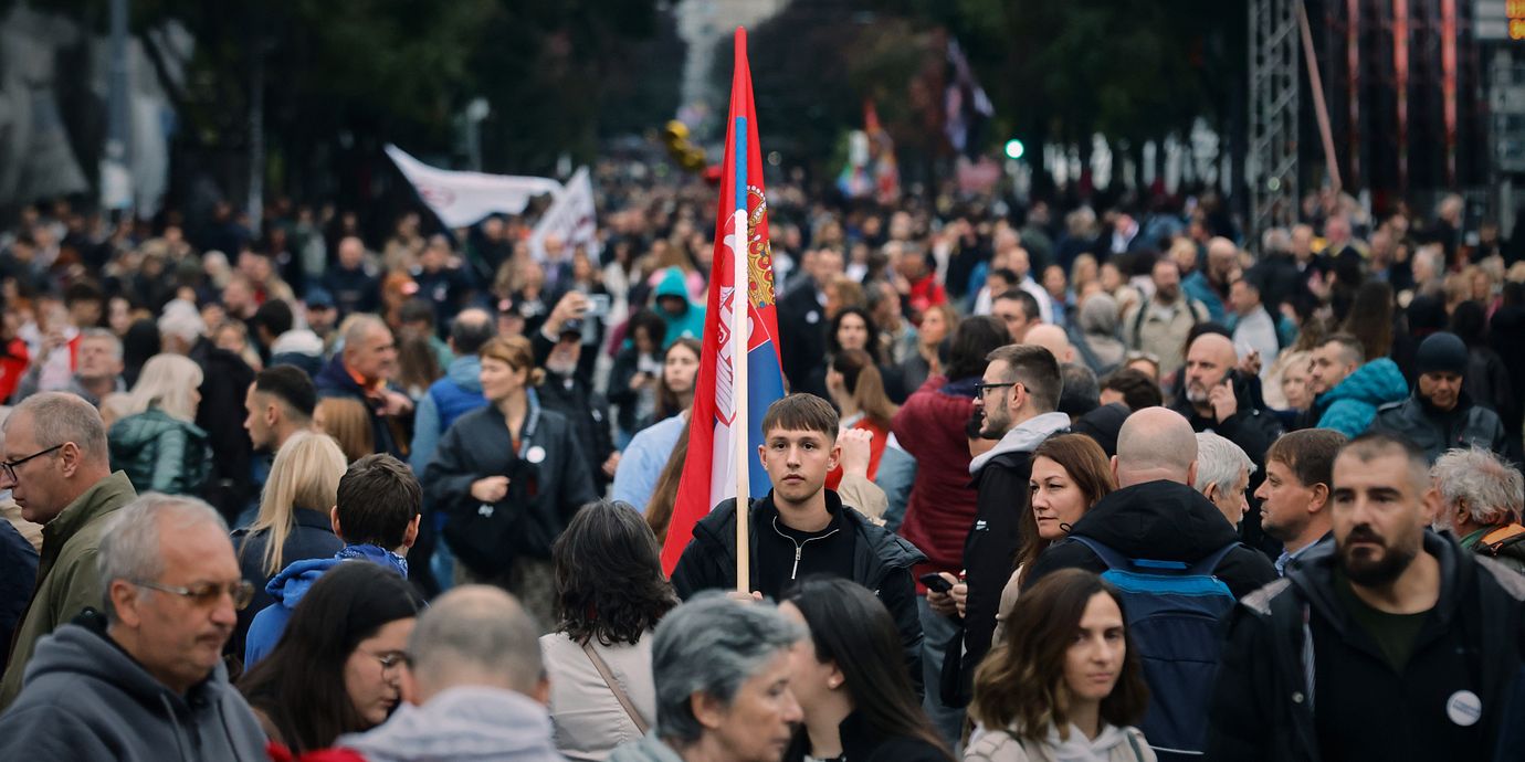 En ung man håller en serbisk flagga under Studentlistans sista demonstration inför parlamentsvalet.