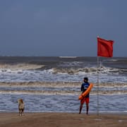 En strandvakt står och inspekterar kusten i Mumbai.